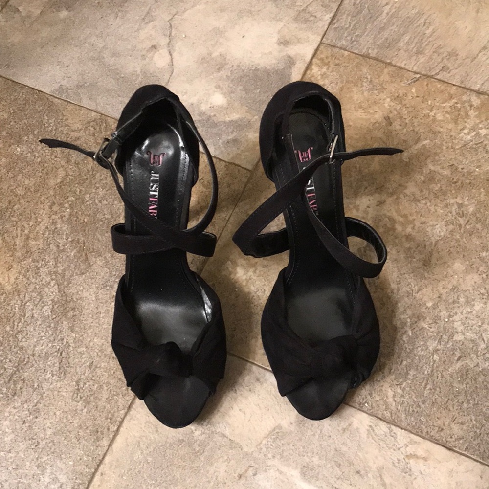 Black straps heals with decorative knot.
